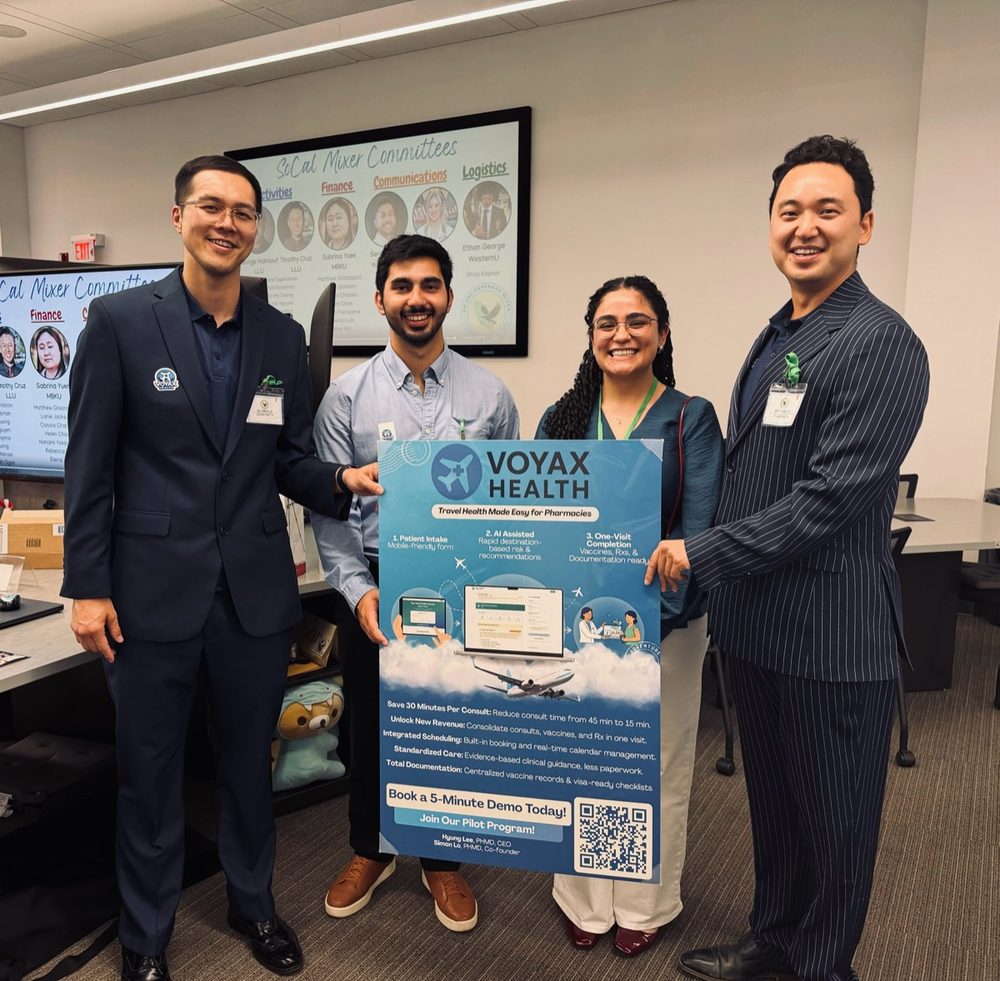 Voyax Health team members holding a Voyax Health poster with attendees at a SoCal mixer